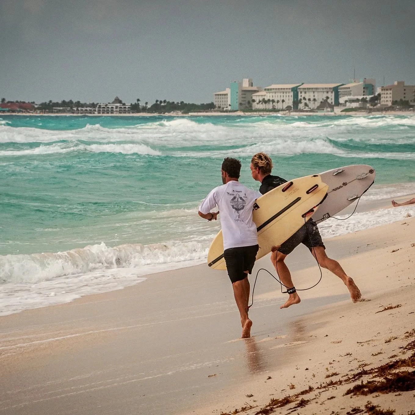 Surfers entering the ocean for a focused session.